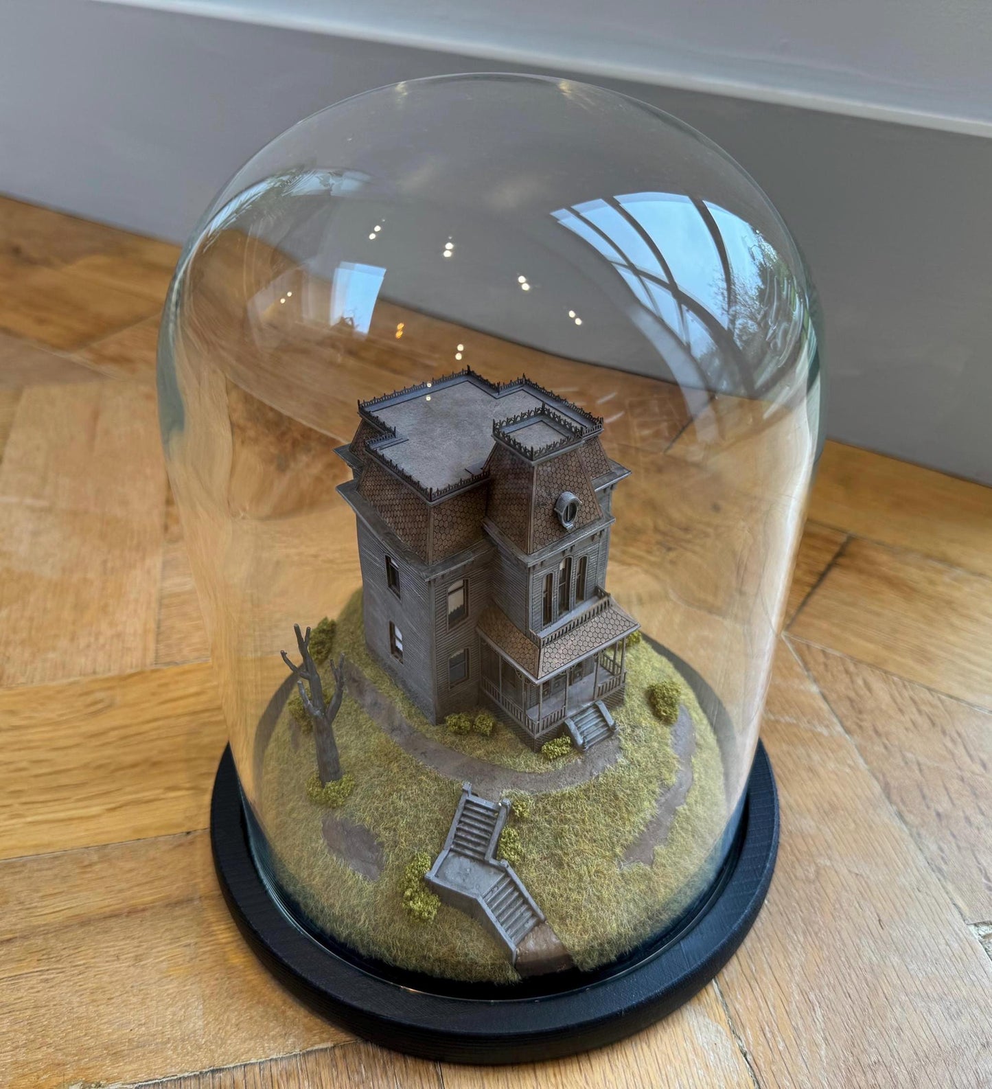 Model of Psycho movie house in glass dome. Bates Motel. Hitchcock