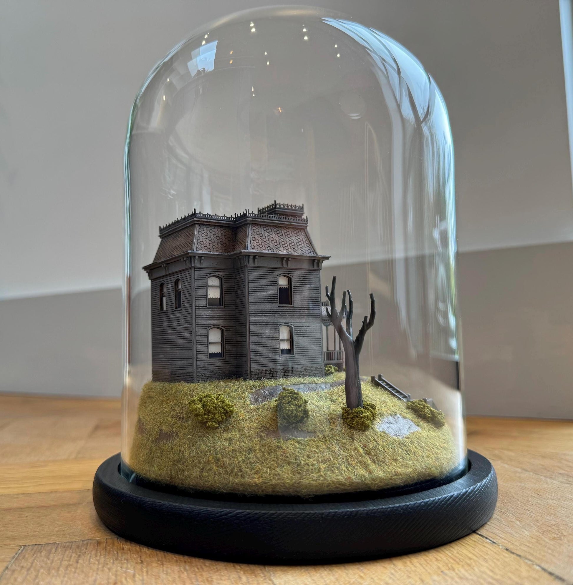 Model of Psycho movie house in glass dome. Bates Motel. Hitchcock